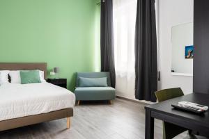 een slaapkamer met een bed, een stoel en een bureau bij Le Cinque Stanze Palermo Room&Breakfast in Palermo
