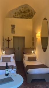 a hotel room with two beds and a table at Villa Alta - Residenza d'epoca con piscina in San Giuliano Terme