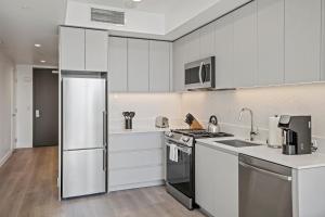 a kitchen with white cabinets and a stove top oven at WhyHotel by Placemakr, San Jose in San Jose