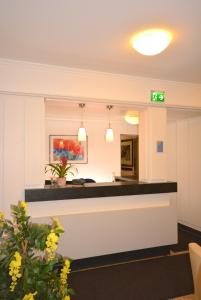 an office lobby with a reception counter and flowers at Hotel Kehrenkamp in Hagen