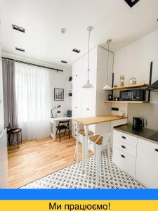 a kitchen with a table and a dining room at Poetry Apartments in the city center in Kharkiv