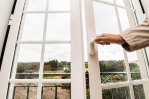 a person opening a door to a window at Casa do Melro in Óbidos