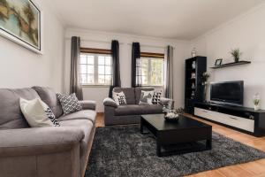 a living room with a couch and a tv at Casa do Melro in Óbidos