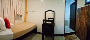 Dormitorio con cama con espejo y tocador en Amax Inn Cebu, en Cebú