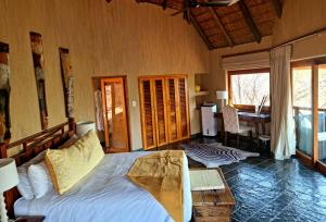 ein Schlafzimmer mit einem Bett und einem Tisch darin in der Unterkunft Sekala Private Game Lodge in Welgevonden Game Reserve