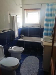 a bathroom with a toilet and a tub and a sink at Casa Campos in Nazaré +6 photos