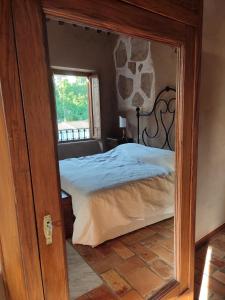 um quarto com uma cama e um espelho em Dimore Santa Maria em Carbognano