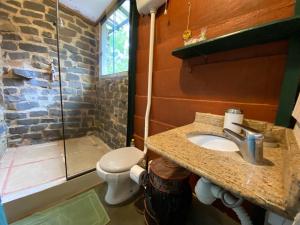 a bathroom with a sink and a toilet and a shower at Pousada dos Anjos in Cunha