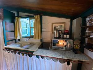 uma cozinha com um lavatório e um balcão com um fogão em Pousada dos Anjos em Cunha