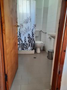 een badkamer met een toilet en een deur met een gordijn bij Studios Marin in Kokkari