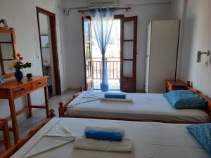 two beds in a room with a window at Studios Marin in Kokkari