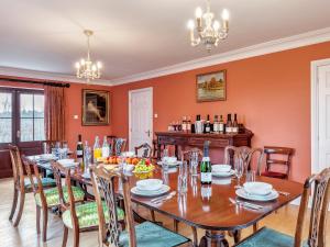 a dining room with a long table and chairs at Tuffon Hall Farmhouse in Halstead