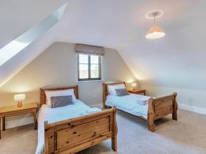 a bedroom with two beds and a window at Tuffon Hall Farmhouse in Halstead