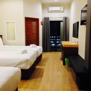 a hotel room with two beds and a sink at Bird Day Boutique Hotel in Mukdahan