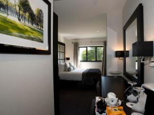 a hotel room with a bed and a window at The Lodge at Kingswood in Epsom