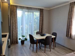 a dining room with a table and chairs and a large window at Home in Udabno in Udabno