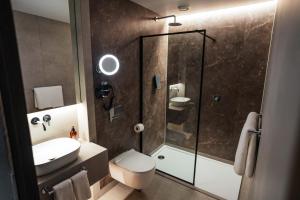 a bathroom with a shower and a toilet and a sink at Konvin Hotel by Reykjavik Keflavik Airport in Keflavík