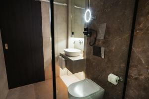 a bathroom with a toilet and a sink with a light at Konvin Hotel by Reykjavik Keflavik Airport in Keflavík