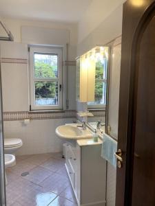 een badkamer met een wastafel, een toilet en een raam bij Terra del Sasso Country-house in Sasso di Castalda