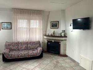 een woonkamer met een bank en een open haard bij Terra del Sasso Country-house in Sasso di Castalda