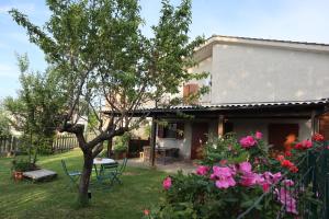 una casa con un patio con una mesa y flores en Villa Strada dei Monti Sibillini, en Montefortino