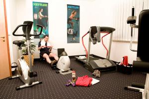 a man sitting on a treadmill in a gym at LandKomfort Hotel Elsenmann in Willingen
