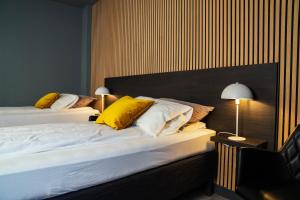 a bedroom with two beds with yellow pillows at Konvin Hotel by Reykjavik Keflavik Airport in Keflavík