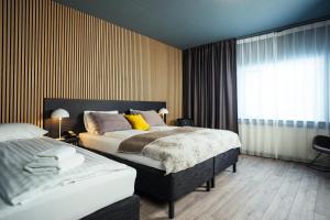 a hotel room with two beds and a window at Konvin Hotel by Reykjavik Keflavik Airport in Keflavík