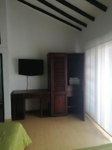 a bedroom with a tv and a dresser with a cabinet at Beraka Boutique in Villa de Leyva