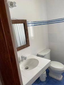 a white bathroom with a sink and a toilet at Beachfront, 4BR, entire house in Paracas in Paracas