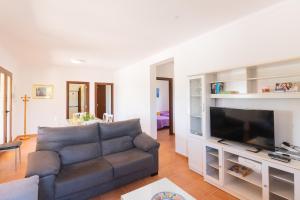 a living room with a couch and a flat screen tv at Villa Son Sala Nou in Campos