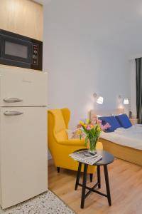 a room with a bed and a table with a vase of flowers at Cosy and Stylish Studio next to Sofia's Central Market Hall in Sofia