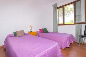 two purple beds in a room with a window at Villa Son Sala Nou in Campos +20 photos
