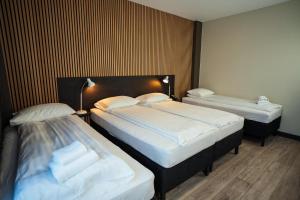 two beds in a hotel room with two bedsvisor at Konvin Hotel by Reykjavik Keflavik Airport in Keflavík