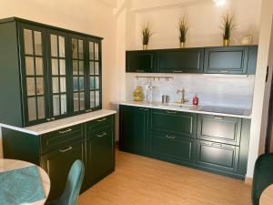 una cocina con armarios verdes y fregadero en B&B Smeralda, en Villa San Giovanni