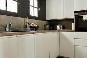 a kitchen with white cabinets and a sink at Louvre Penthouse PadATerre Owner Direct since 1999 in Paris