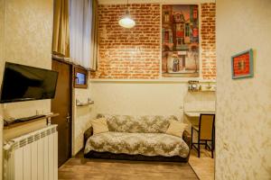 sala de estar con sofá y pared de ladrillo en Luky apartment on Rustaveli Ave. en Tiflis