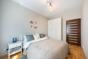 - une chambre blanche avec un lit et une armoire blanche dans l'établissement Wola Prime 2-bedroom Apartment, à Varsovie