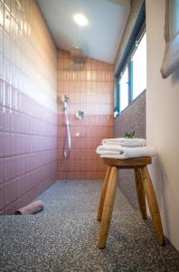 a bathroom with a shower and a table with towels at Kushin rooms Split in Split