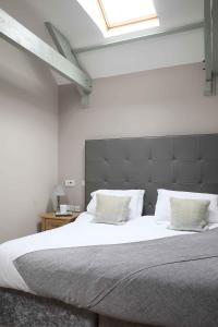 um quarto com uma cama grande com lençóis brancos e almofadas em Chiff Chaff em Belford