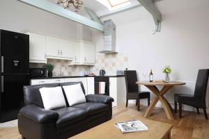 ein Wohnzimmer mit Ledersofa und einem Tisch in der Unterkunft Chiff Chaff in Belford