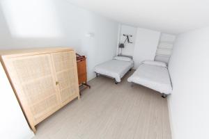 - deux chaises et une commode dans une chambre aux murs blancs dans l'établissement Dúplex Sa Tarongeta, à Cadaqués