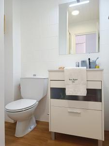 a white bathroom with a toilet and a sink at Bon Repos - B10, Apartamento con Terraza en Cala'n Bosch in Cala en Bosc