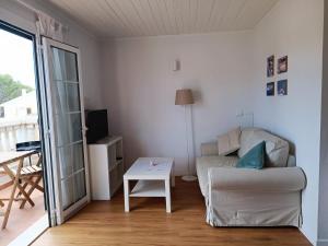 a living room with a couch and a table at Bon Repos - B10, Apartamento con Terraza en Cala'n Bosch in Cala en Bosc