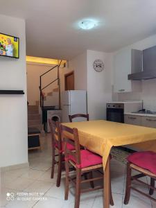 a kitchen with a table and some chairs and a table and a kitchen with at Casa vacanze zaccanopoli in Zaccanopoli