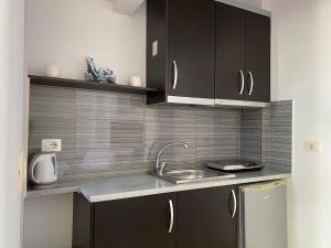 una cucina con lavandino e piano di lavoro di Tomi Apartments a Sarandë