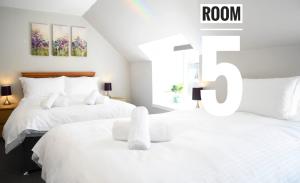 two beds in a bedroom with a room sign at Rooms on the High Street in Portree