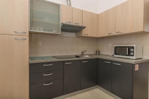 a kitchen with a sink and a microwave at Simba Apartman 59 in Selce