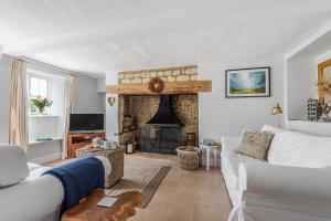 a living room with a white couch and a fireplace at Coombe Cottage in Dorchester