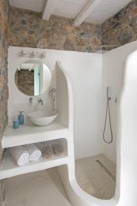 La salle de bains est pourvue d'un lavabo et d'un miroir. dans l'établissement Nisides Suites, à Livadi Astypalaias